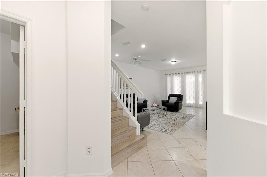 14978 Summit Pl Circle Naples, FL 34119 - Photo 4 of 35 Staircase with tile patterned floors, recessed lighting, and ceiling fan