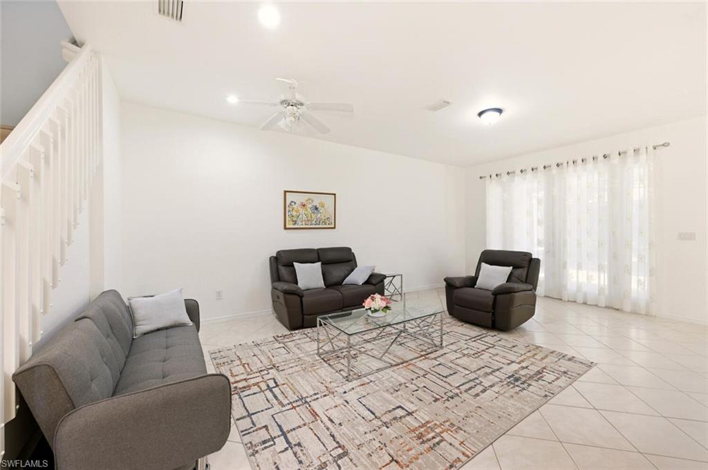 14978 Summit Pl Circle Naples, FL 34119 - Photo 5 of 35 Living area with light tile patterned flooring, a ceiling fan, recessed lighting, and stairs