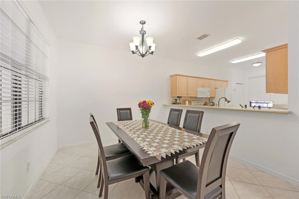 14978 Summit Pl Circle Naples, FL 34119 - Photo 9 of 35 Dining area featuring light tile patterned floors and a chandelier