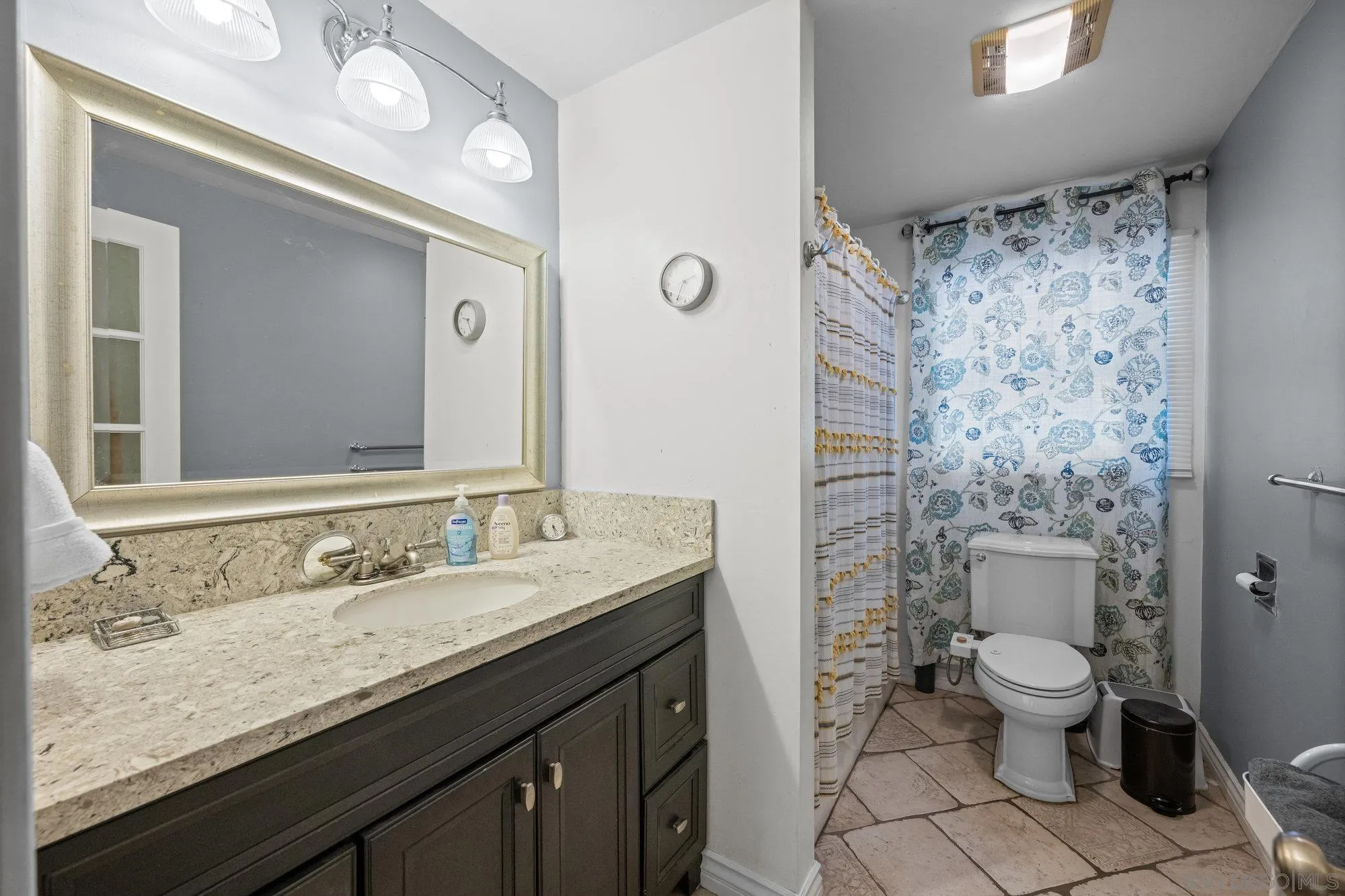 7960 Normal Avenue La Mesa, CA 91941 - Photo 20 of 42 a bathroom with a granite countertop sink a toilet a mirror and shower curtain