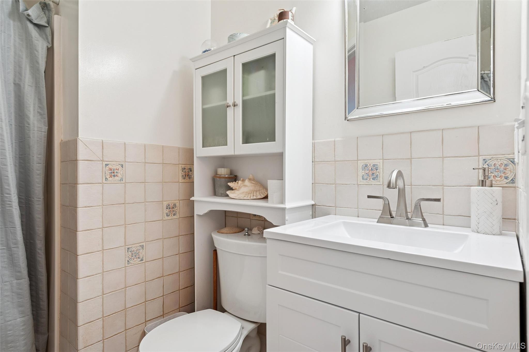 6 Shore Road Southampton, NY 11968 - Photo 14 of 15 Bathroom with tile walls, vanity, wainscoting, and a shower with curtain