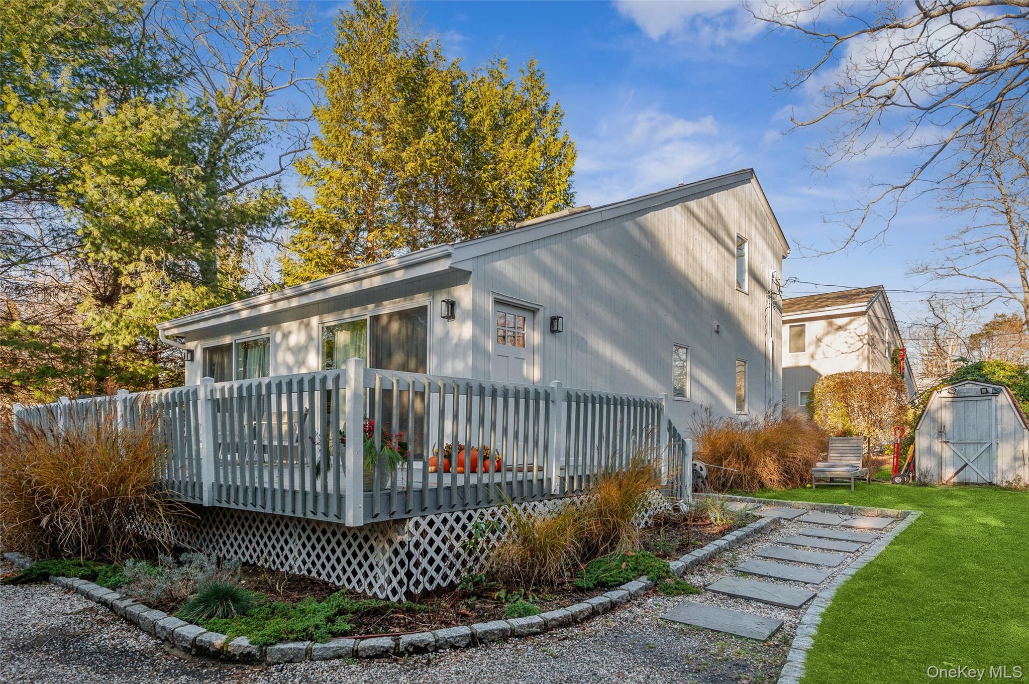 6 Shore Road Southampton, NY 11968 - Photo 2 of 15 Back of house featuring a wooden deck, a lawn, and a storage shed
