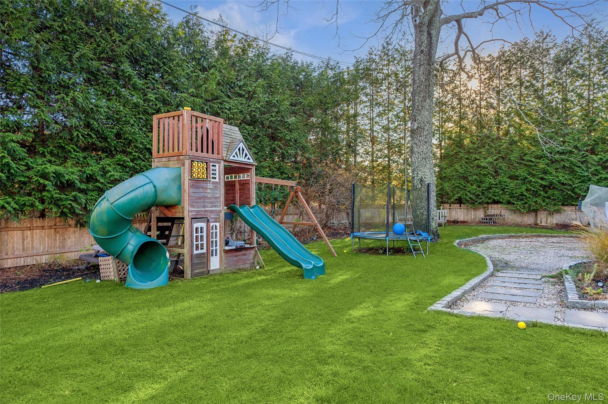 6 Shore Road Southampton, NY 11968 - Photo 7 of 15 View of playground featuring a trampoline and a fenced backyard