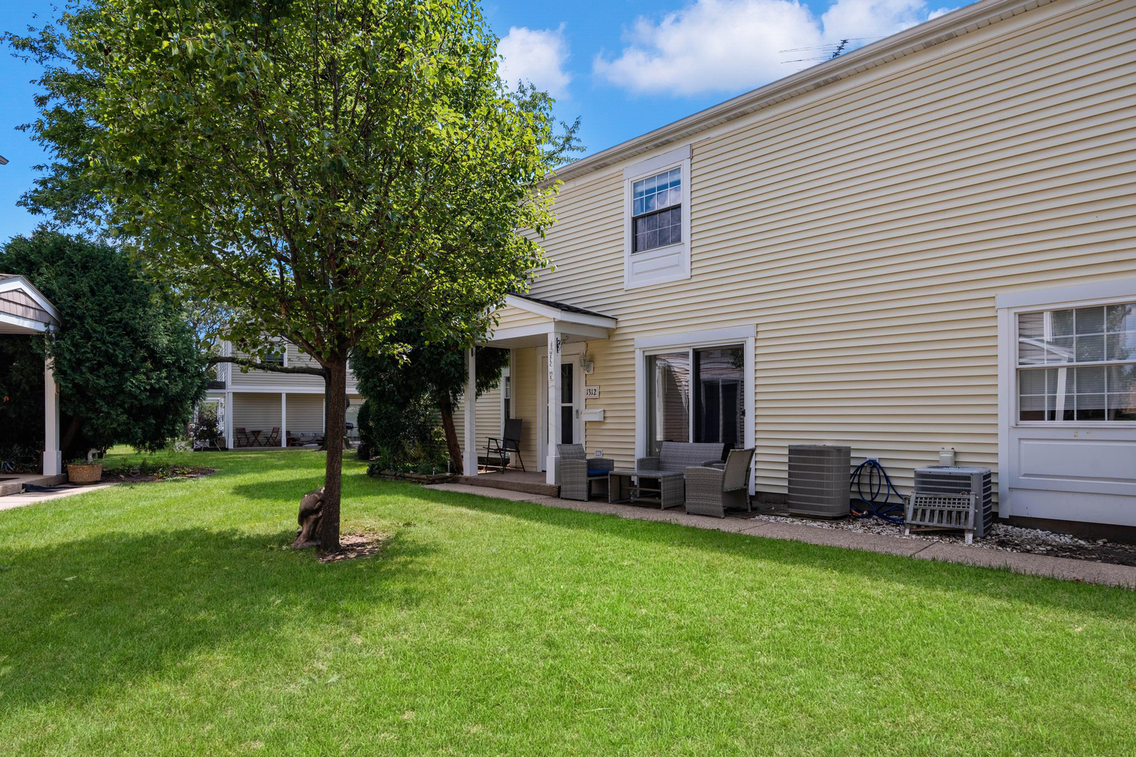 a front view of house with a garden and trees