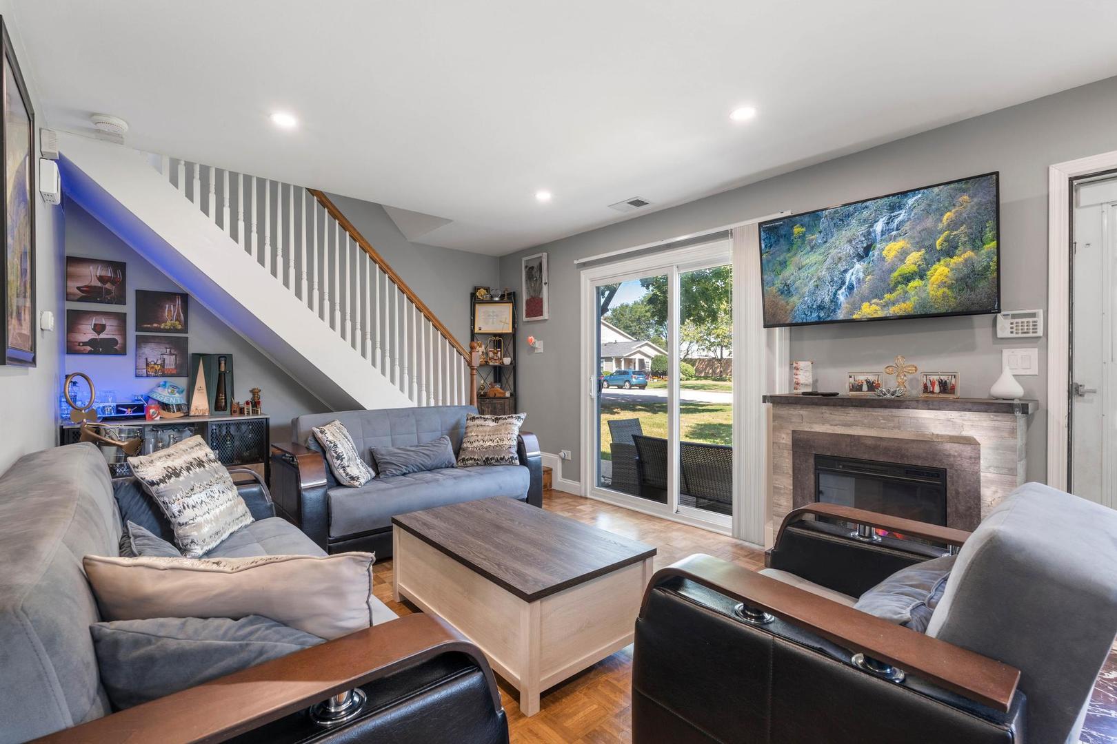 1312 Fall Court, Unit 1312 Wheeling, IL 60090 - Photo 4 of 28 a living room with furniture a flat screen tv and a fireplace