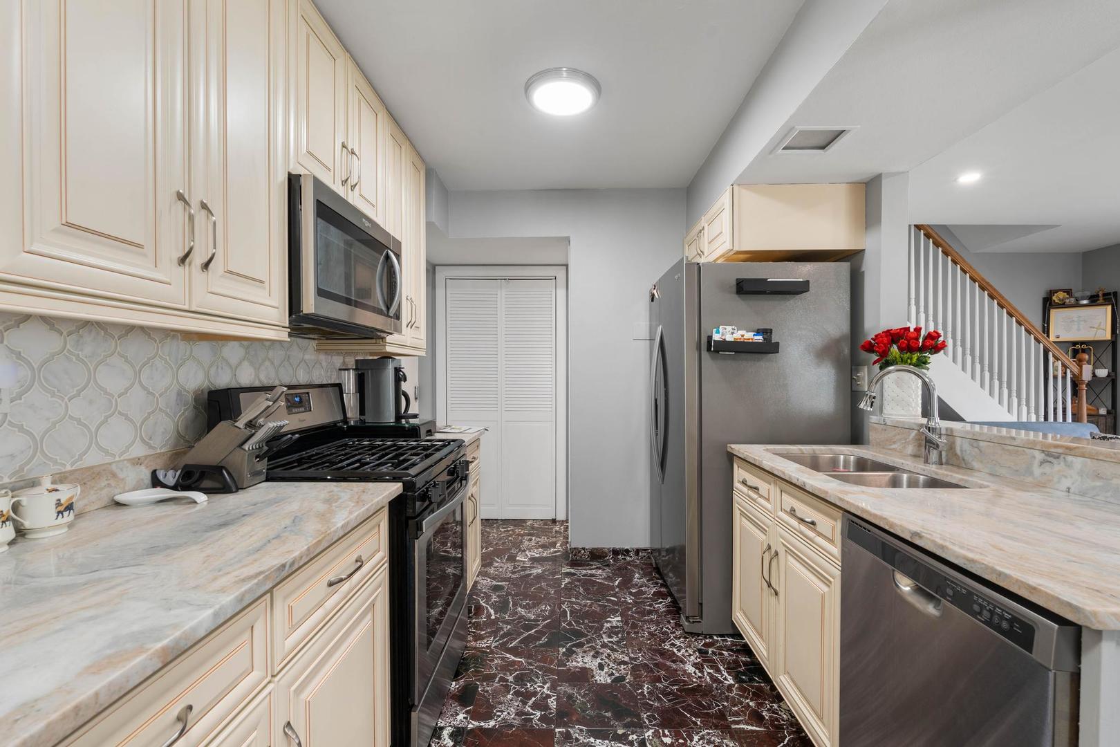 1312 Fall Court, Unit 1312 Wheeling, IL 60090 - Photo 7 of 28 a kitchen with stainless steel appliances granite countertop a sink stove and refrigerator