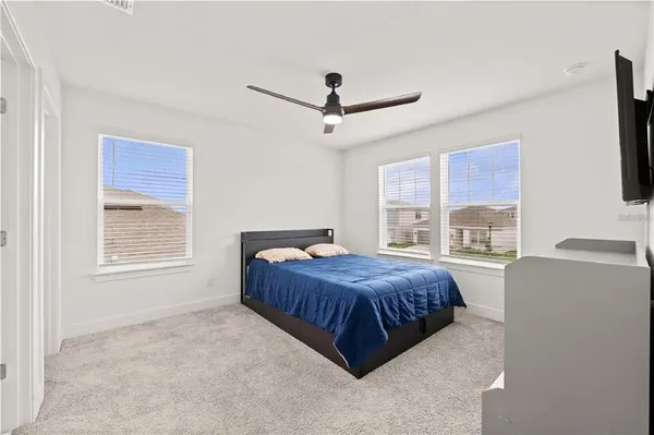 a bedroom with a bed a dresser and a flat screen tv