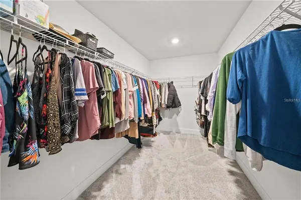 a view of walk in closet with clothes
