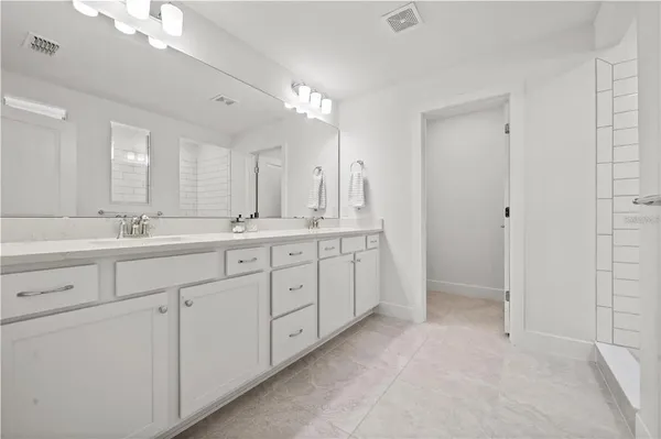 a spacious bathroom with a double vanity sink mirror and double