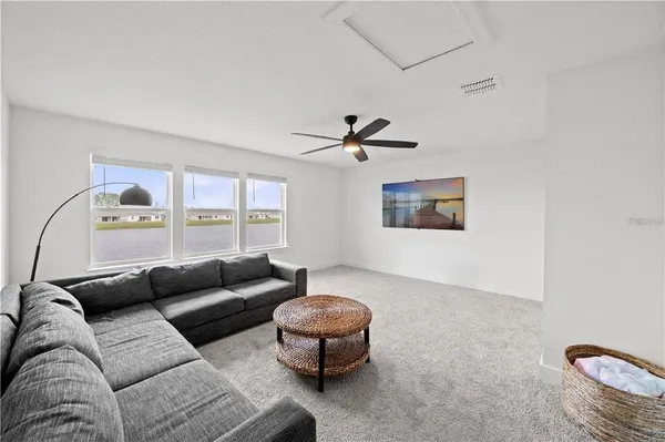 a living room with furniture and a ceiling fan