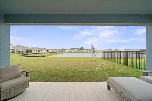 a view of a patio with lawn chairs next to a yard