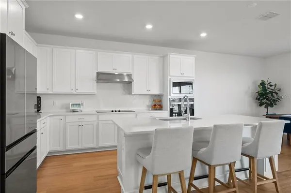 a kitchen with stainless steel appliances granite countertop a white cabinets and wooden floor