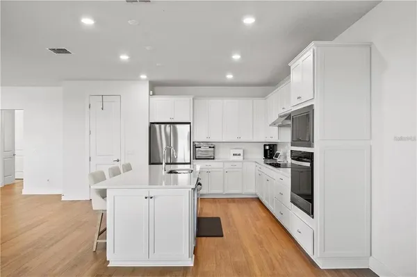 a kitchen with white cabinets and stainless steel appliances