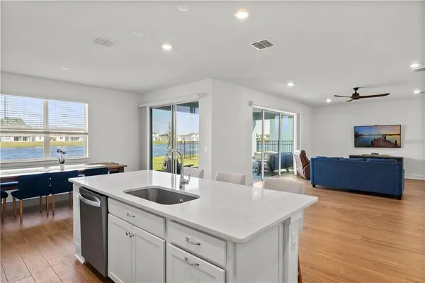 a kitchen with a sink and wooden floor