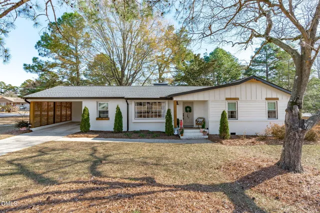 a view of a yard in front of a house with large tree