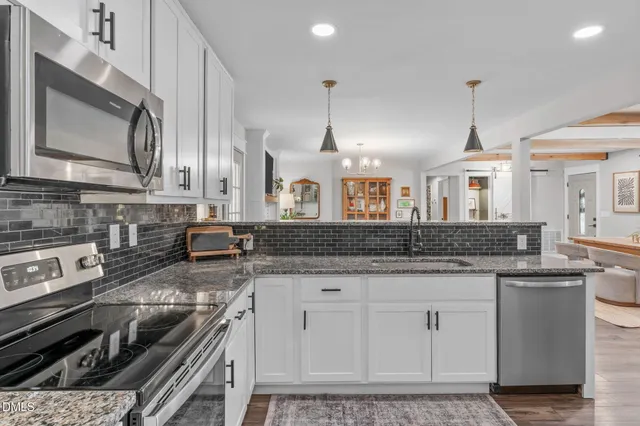 a kitchen with stainless steel appliances granite countertop a refrigerator and a stove