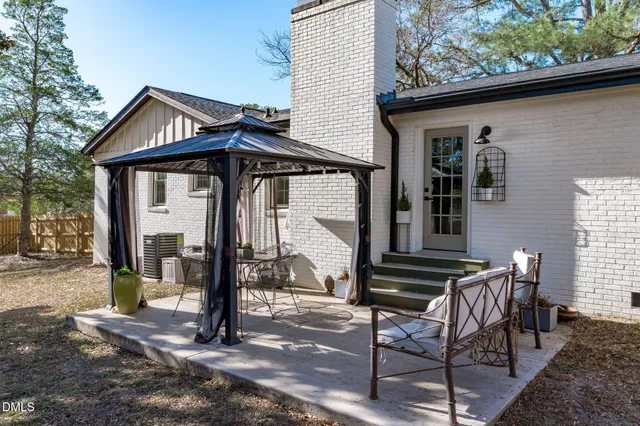 a view of a house with a yard and large tree
