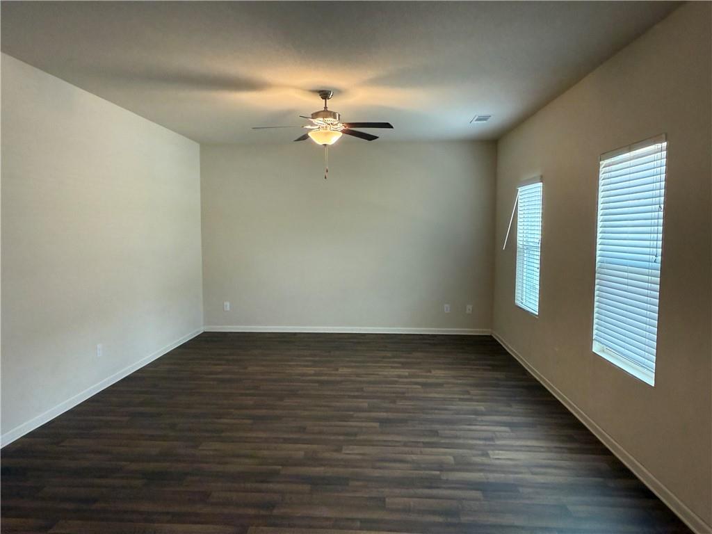 906 Independence Avenue Pendergrass, GA 30567 - Photo 6 of 14 an empty room with wooden floor chandelier fan and windows