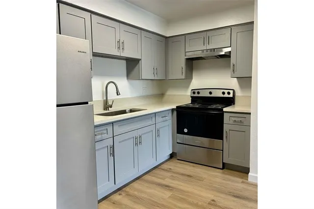 a kitchen with a sink a stove and cabinets