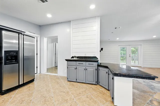 a kitchen with granite countertop a sink and a refrigerator