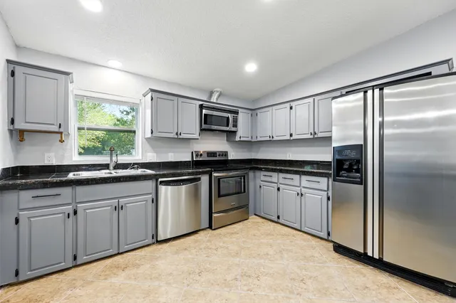 a kitchen with stainless steel appliances granite countertop a refrigerator sink and cabinets