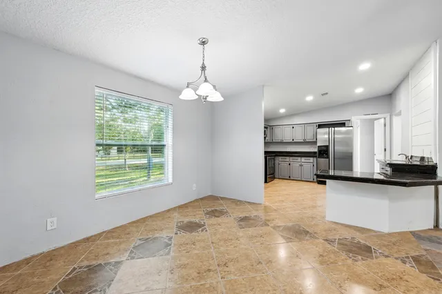 a view of a kitchen with kitchen island and stainless steel appliances
