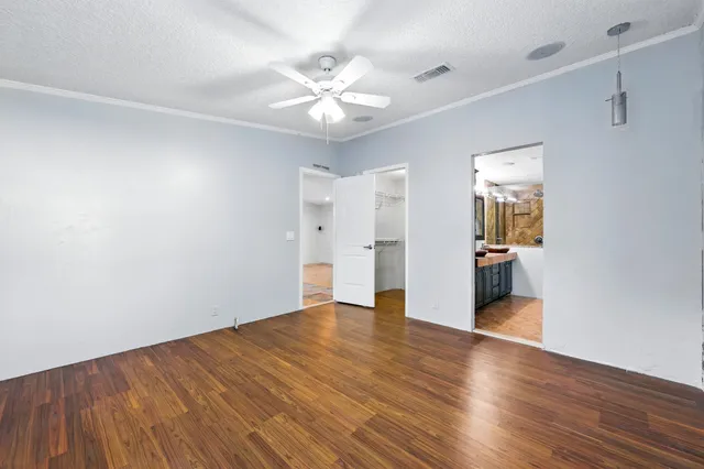 a view of an empty room with wooden floor