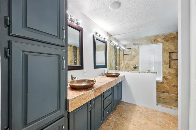 a bathroom with a granite countertop sink and a mirror