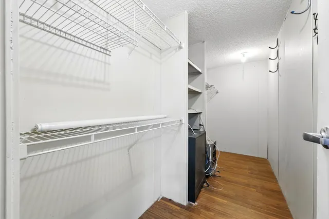 a view of a hallway with closet and wooden floor