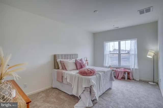 a bedroom with a bed and a large window