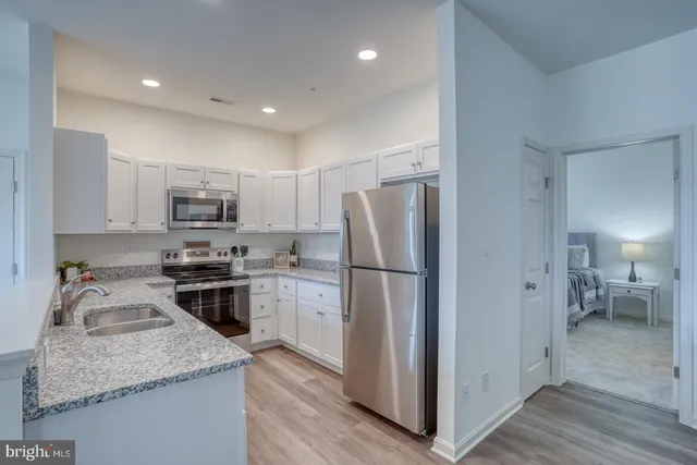 a kitchen with stainless steel appliances granite countertop a refrigerator stove microwave and sink