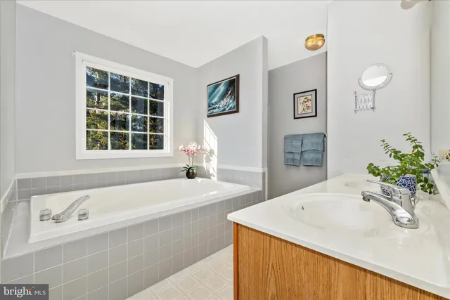 a bathroom with a tub sink and mirror