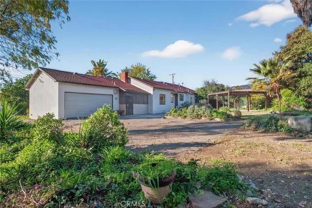 a view of a house with a street and a yard