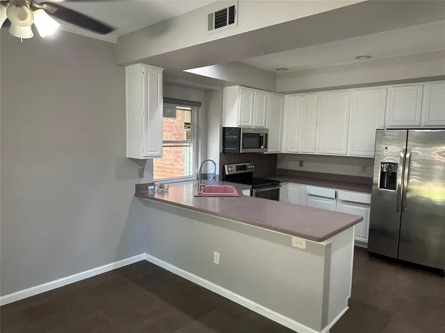 a kitchen with kitchen island a sink stainless steel appliances and window