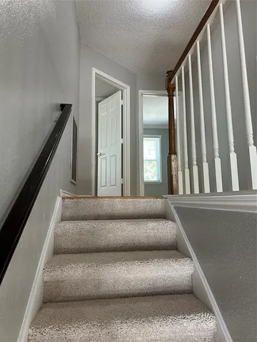 a living room with furniture and stairs