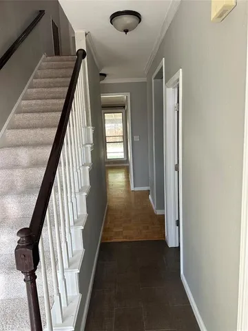 a view of a hallway with wooden floor and stairs