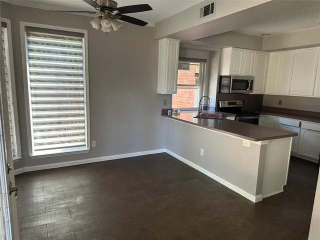 a kitchen with granite countertop a stove a sink and a microwave