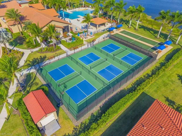 a view of a tennis ground with large trees