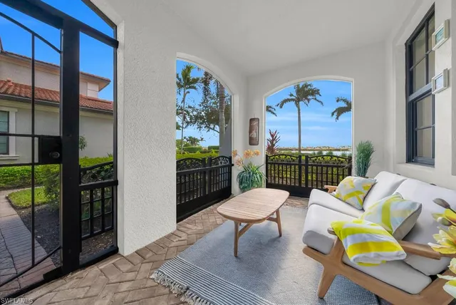 a living room with patio furniture and a potted plant