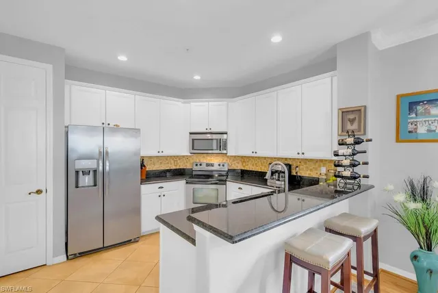 a kitchen with refrigerator and chairs