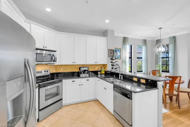 a kitchen with stainless steel appliances a sink stove and cabinets