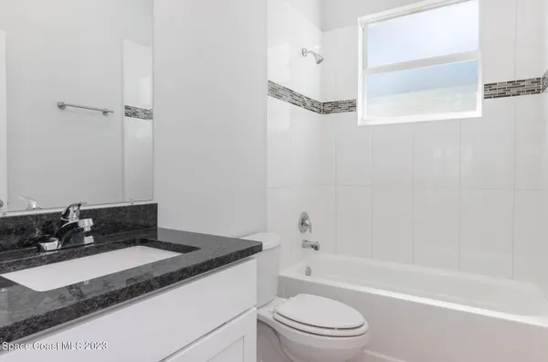 a bathroom with a granite countertop sink a toilet and bathtub
