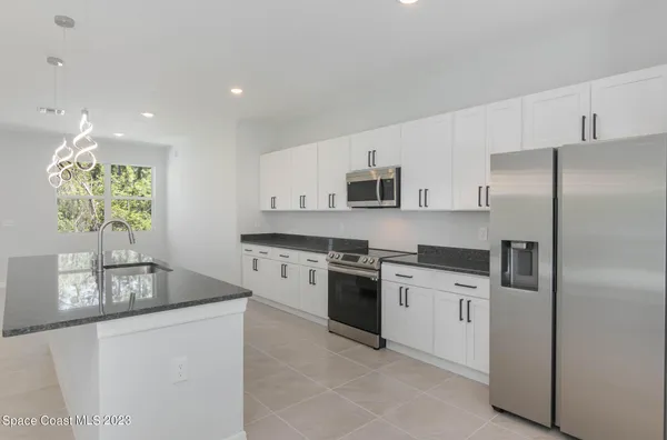 a kitchen with stainless steel appliances granite countertop a stove a sink and a refrigerator