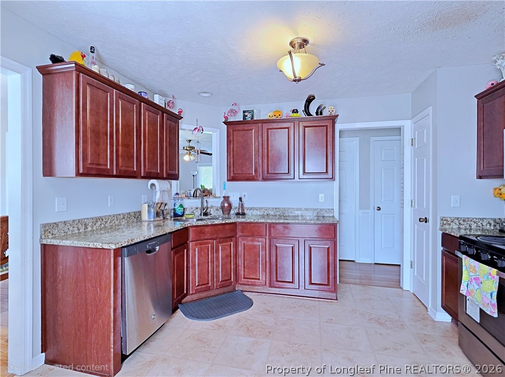 5218 Pringle Way Hope Mills, NC 28348 - Photo 12 of 43 a kitchen with stainless steel appliances granite countertop a sink dishwasher stove and cabinets
