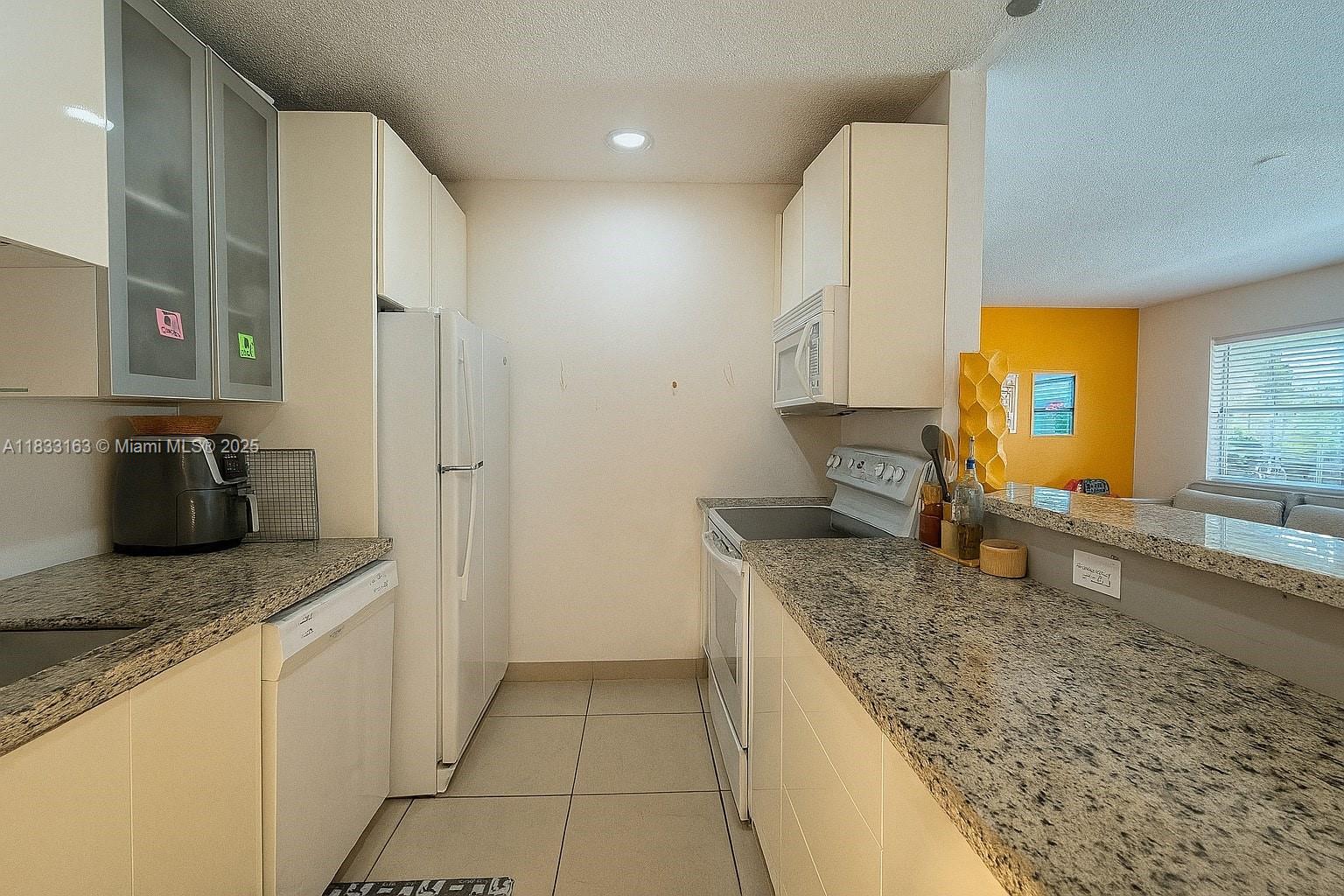 13101 Memorial Highway, Unit 215 Miami, FL 33161 - Photo 4 of 13 a kitchen with stainless steel appliances granite countertop a sink stove and refrigerator