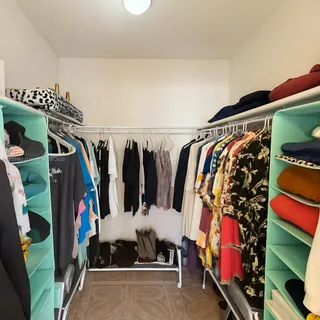 a view of walk in closet with clothes and shoes
