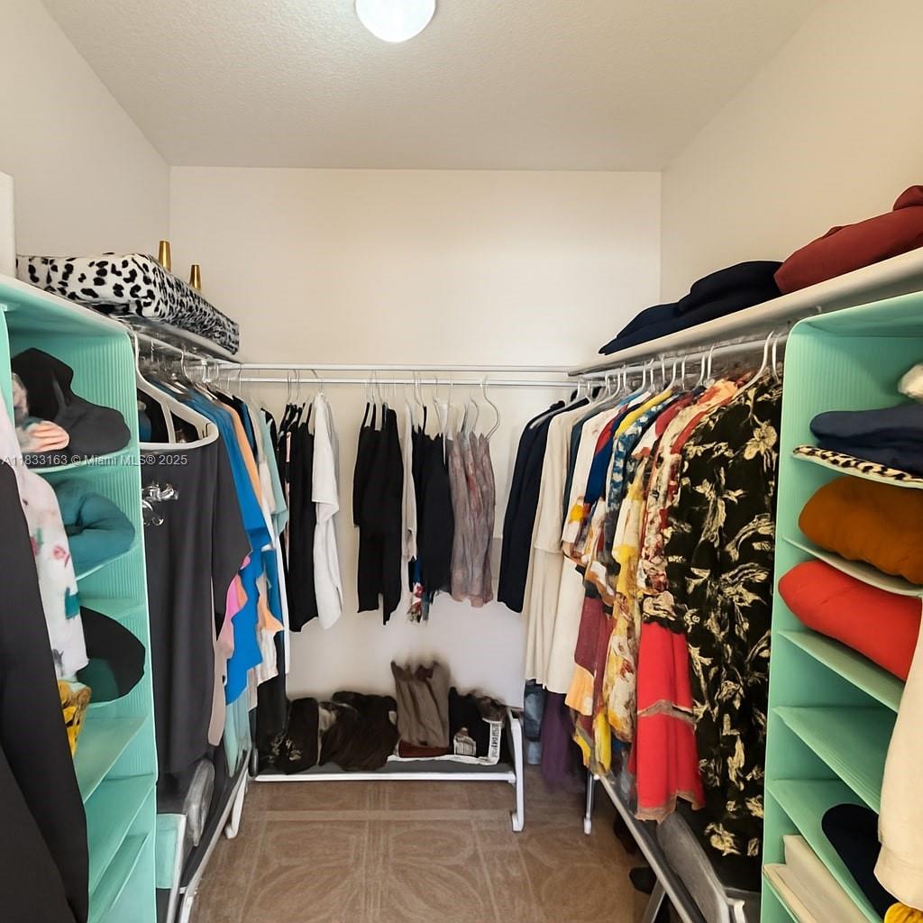 13101 Memorial Highway, Unit 215 Miami, FL 33161 - Photo 7 of 13 a view of walk in closet with clothes and shoes