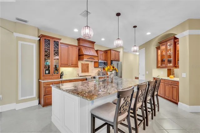 a kitchen with stainless steel appliances granite countertop a kitchen island a stove a table and chairs