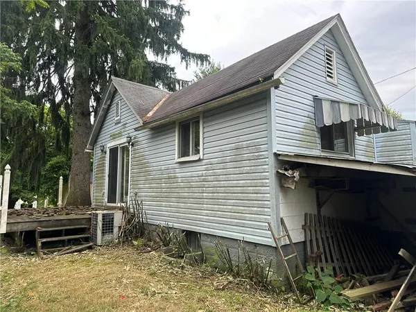 a view of a house with a yard and wooden fence