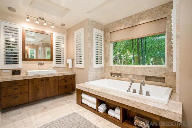 a spacious bathroom with double vanity and a large mirror